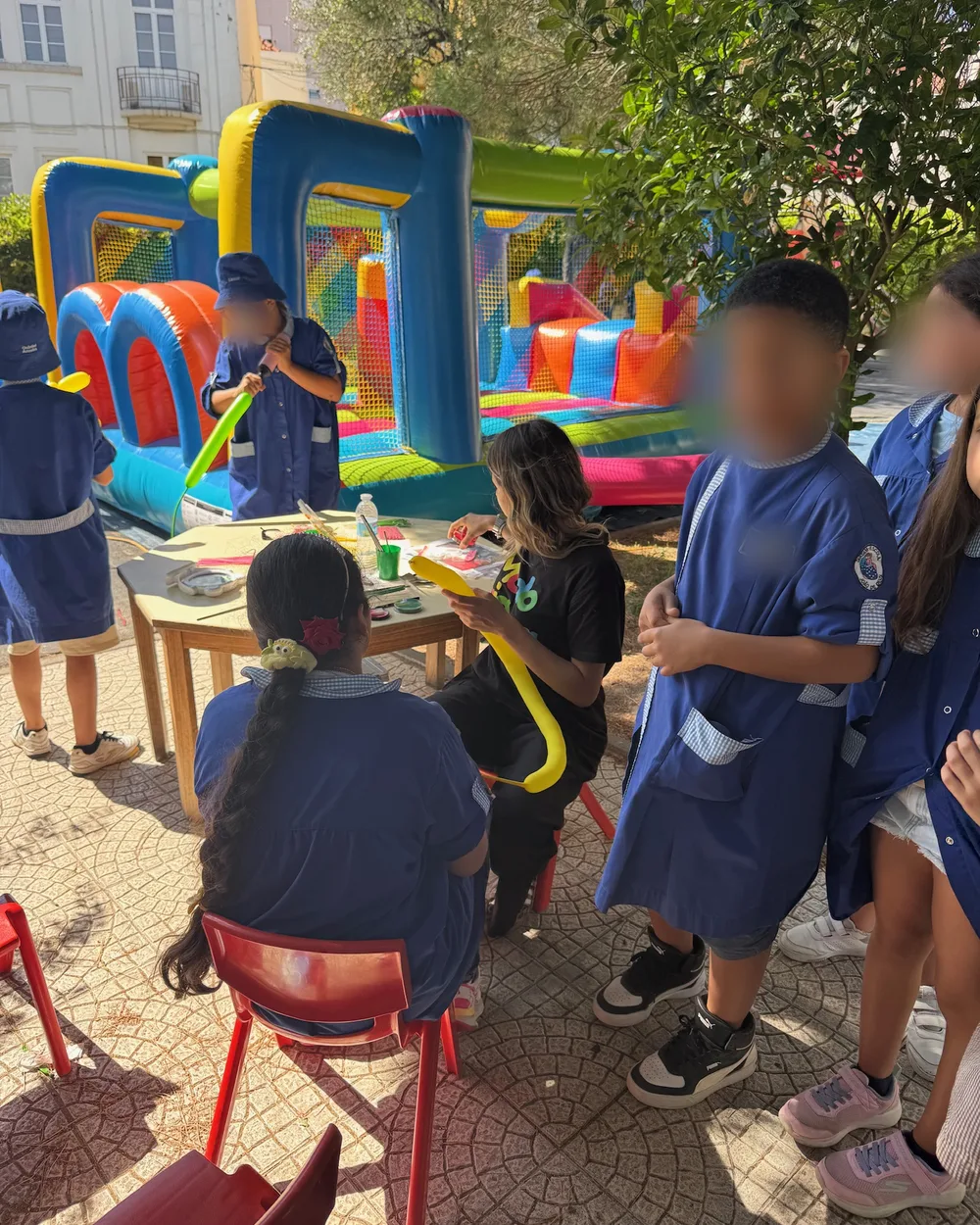 Alunos em atividade no recreio da escola com insuflável ao fundo