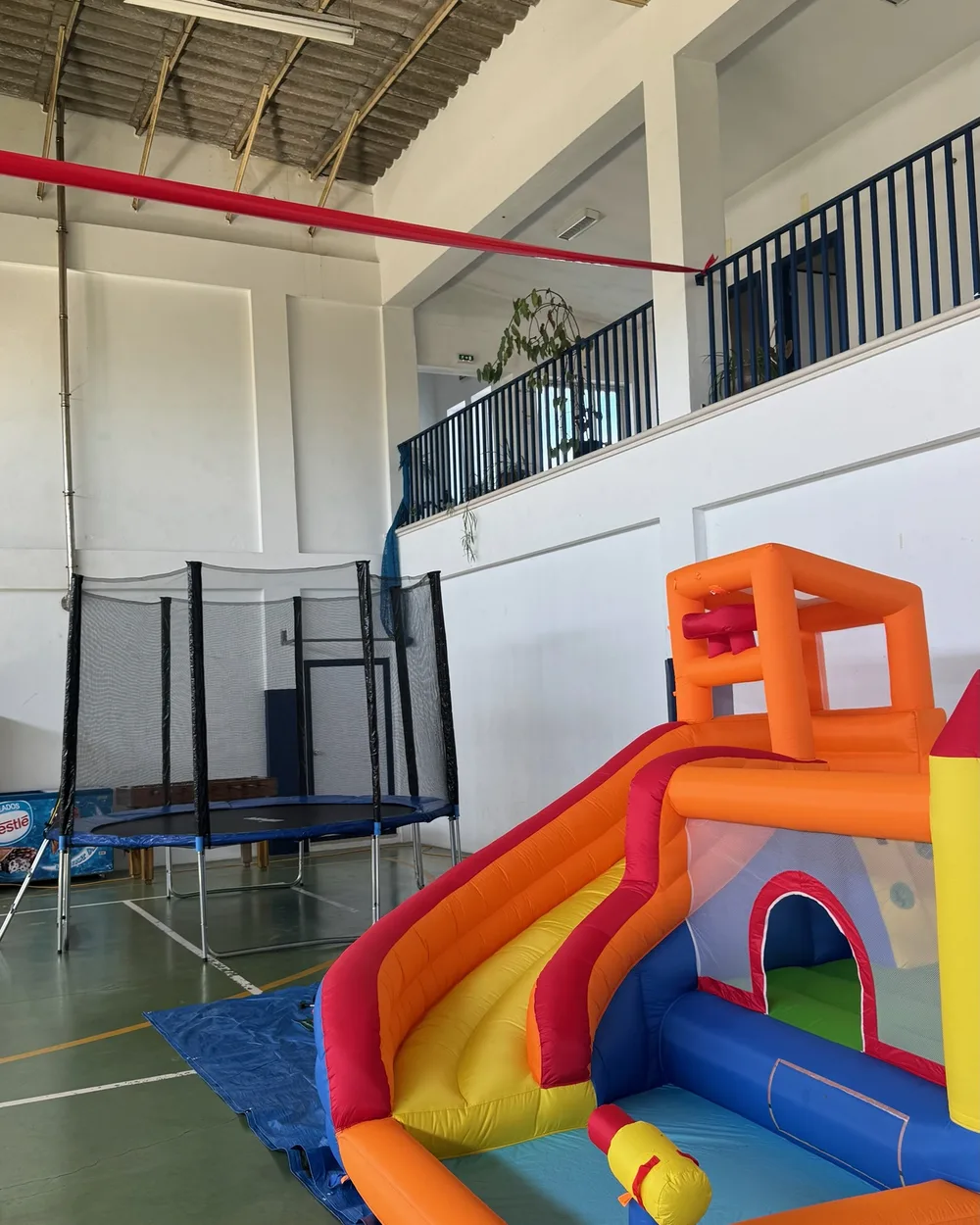 Insuflável e trampolim montados no pavilhão de uma escola